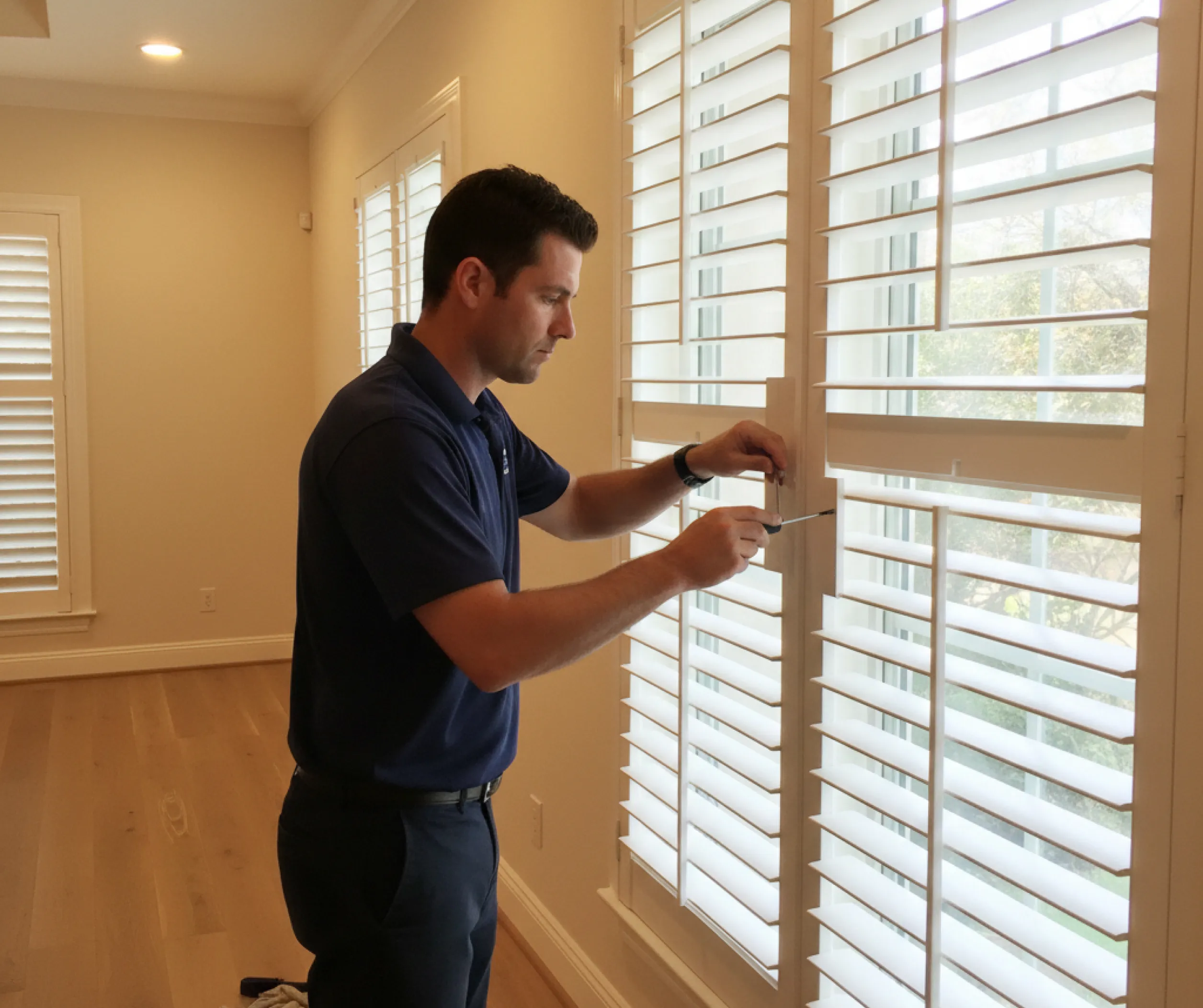 technician-cleaning-white-plantation-shutters-coastal-decor@4x